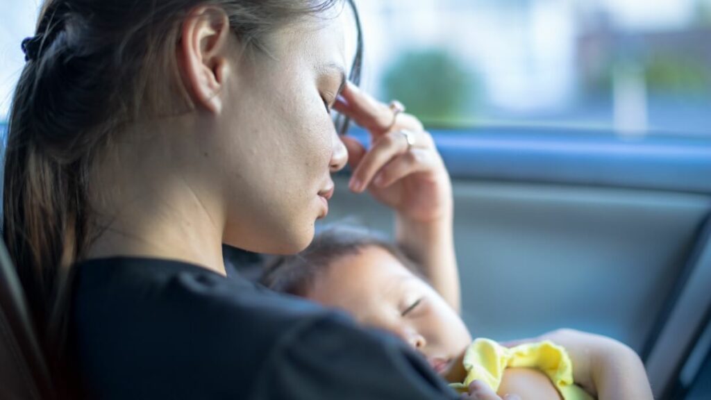 Tired stressed mother holding baby